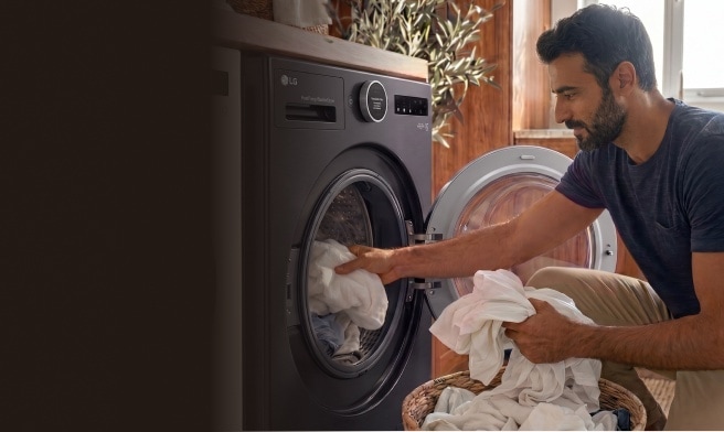 Mann mit Smartphone in einem modernen Waschraum mit LG Waschmaschine, Trockner und Kühlschrank, umgeben von Grafiken zur Energieeffizienz.	