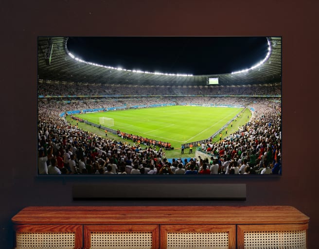Fernseher zeigt eine weite Ansicht eines Fußballstadions während eines Spiels