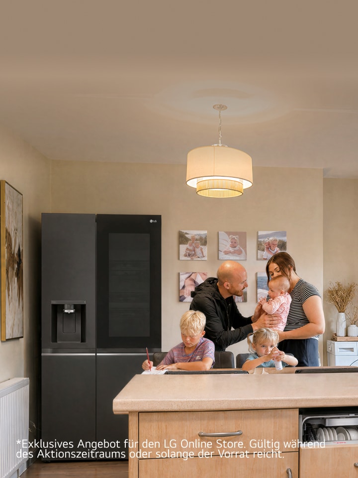 Eine Familie versammelt sich in einer Küche neben einem Edelstahl-LG-Kühlschrank – ein Junge schreibt am Esstisch, ein junges Mädchen sitzt neben ihm mit einer kleinen Flasche, und Eltern stehen zusammen und halten ein Baby.