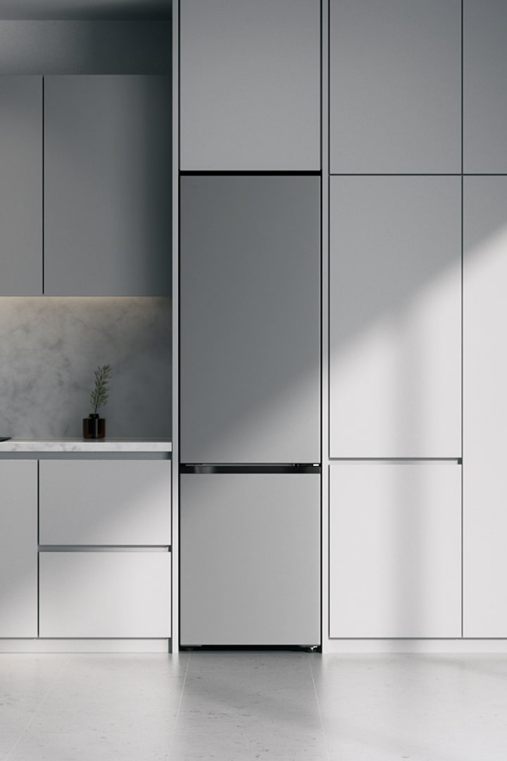 LG Unterer Gefrierschrank, Prime Silver (GBBS726CPY), eingebaut in graue Schränke neben Marmorarbeitsplatte mit Induktionskochfeld und großem Fenster rechts