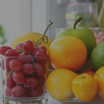 Nahaufnahme eines mehrtürigen LG Kühlschranks mit verschiedenen frischen Obst- und Gemüsesorten.