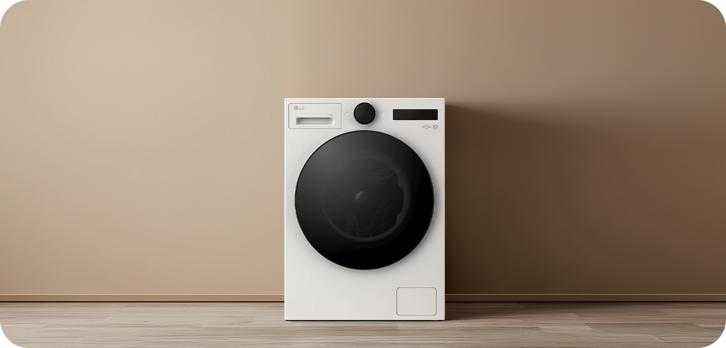 A white front-loading washing machine is centered against a beige wall and wooden floor. A dial and display are located at the top, the detergent drawer is on the left, and a black circular door is in the center.