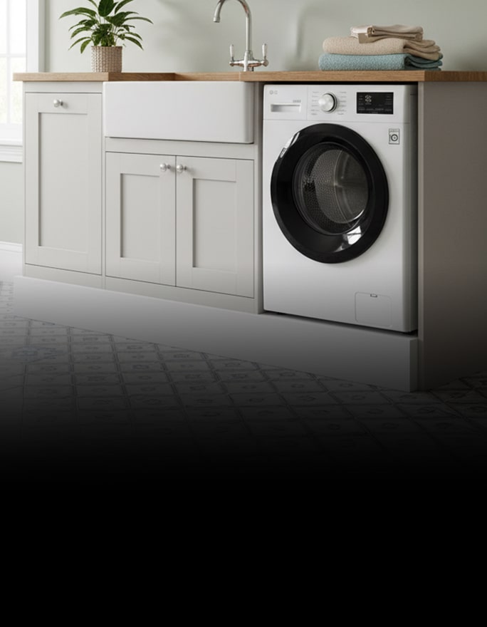 A white front-loading dryer is built into a wooden enclosure, with neatly arranged towels and bottles on the shelf above.