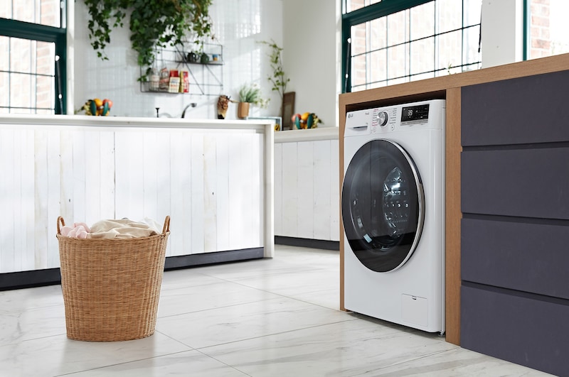 Die weiße LG 11 kg Waschmaschine F4WR7011 mit elegantem Design, installiert in einem modernen Waschraum, mit Energieeffizienzklasse A-10%.