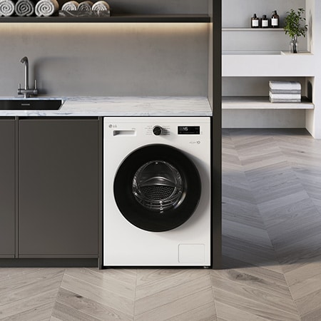 Die LG 8 kg Waschmaschine F4WB308Y in Essence White, unterbaufähig in einem modernen Waschraum installiert, mit Energieeffizienzklasse A.