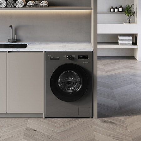 Die LG 9 kg Waschmaschine F4WB309YB in der Farbe Dark Stone, unterbaufähig installiert in einem modernen Waschraum, mit Energieeffizienzklasse A.