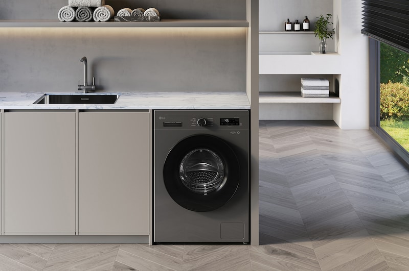 Die LG 8 kg Waschmaschine F4WB308YB in der Farbe Dark Stone, unterbaufähig installiert in einem modernen Waschraum, mit Energieeffizienzklasse A.