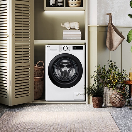 Die weiße LG 11 kg Waschmaschine F4WR4016 mit markantem schwarzem Bullaugenring, installiert in einem stilvollen, modernen Waschraum, mit Energieeffizienzklasse A.