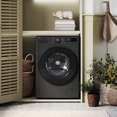 Der schwarze LG 9 kg Slim-Waschtrockner V5WD95SLIMB, mit seinem platzsparenden Design in einem stilvollen Wäscheschrank installiert, mit Energieeffizienzklasse E.
