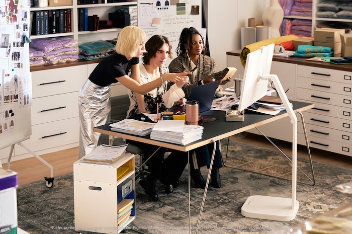 LG UltraFine 32U889SA-W Monitor in einem modernen Büro, genutzt für kreative Zusammenarbeit im Team, harmonisch integriert in die Arbeitsumgebung.