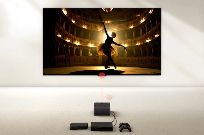 Zero Connect Box mit Spielkonsole und Set-Top-Box verbunden, überträgt kabellos eine Ballettaufführung auf den LG OLED evo AI M4 4K Smart TV Fernseher.