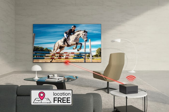 Zero Connect Box auf Beistelltisch, überträgt kabellos Springreitvideo auf den LG OLED evo AI M4 4K Smart TV Fernseher im modernen Wohnraum.