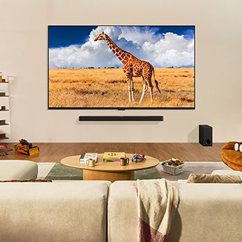 LG QNED80 AI 4K Smart Fernseher an der Wand montiert in einem Familienzimmer, zeigt ein lebendiges Bild einer Giraffe in der Savanne.