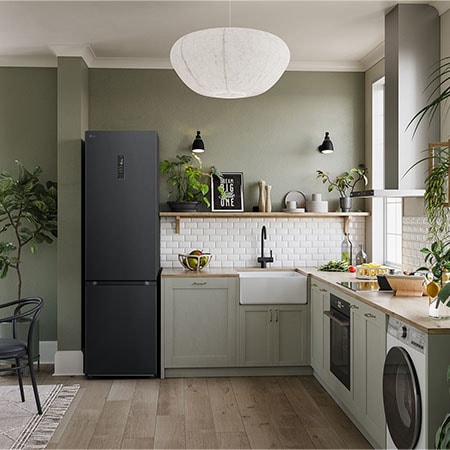 LG Kühl-Gefrierkombination GBV5250CEP in Essence Matte Black, 203 cm hoch, integriert in eine moderne, grüne Küche, demonstriert ihr elegantes Flat Door Design.