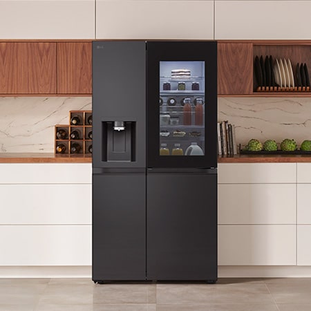 LG Side-by-Side Kühlschrank GSXE91EVAD in mattem Schwarz mit InstaView™ Door-in-Door®, integriert in eine moderne Küche mit weißen und hölzernen Schränken.