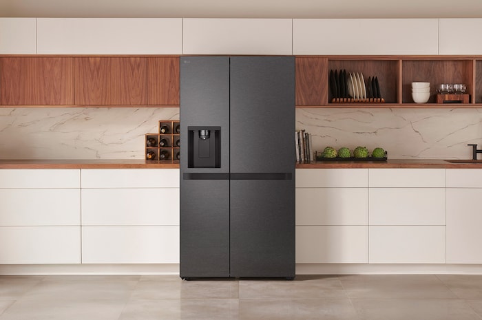LG Side-by-Side Kühlschrank GSLC41EPPE in mattem Schwarzstahl, elegant integriert in eine moderne Küche mit weißer und hölzerner Arbeitsplatte und integriertem Wasserspender.