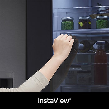 LG Side-by-Side GSXV91MCAE zeigt **InstaView** Door-in-Door: Eine Hand greift nach einer Flasche durch die halb geöffnete Innentür, wobei das beleuchtete Fach sichtbar ist.