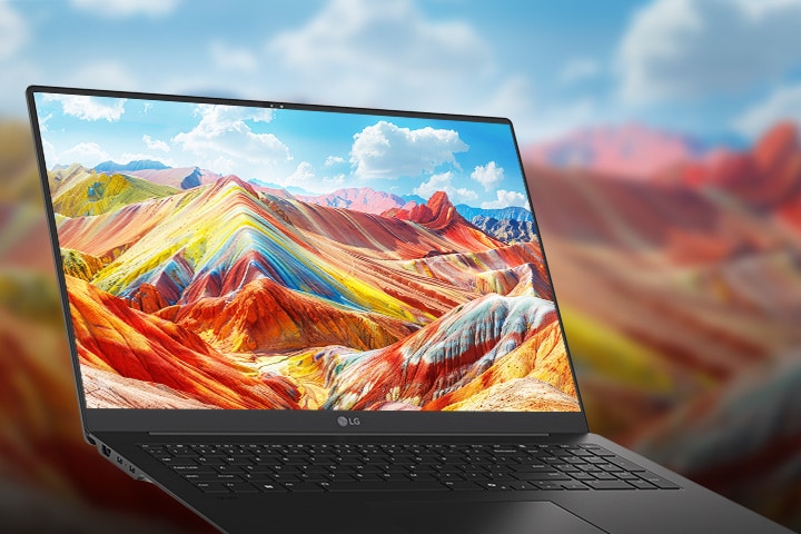 Ein Laptop, der auf seinem Bildschirm eine lebendige und farbenfrohe Landschaft mit leuchtenden Bergen zeigt, wobei die hohe Auflösung und die satte Farbwiedergabe besonders hervorstechen. Im Hintergrund ist eine unscharfe Version derselben Landschaft zu sehen, um die Aufmerksamkeit auf die Bildschirmqualität zu lenken.