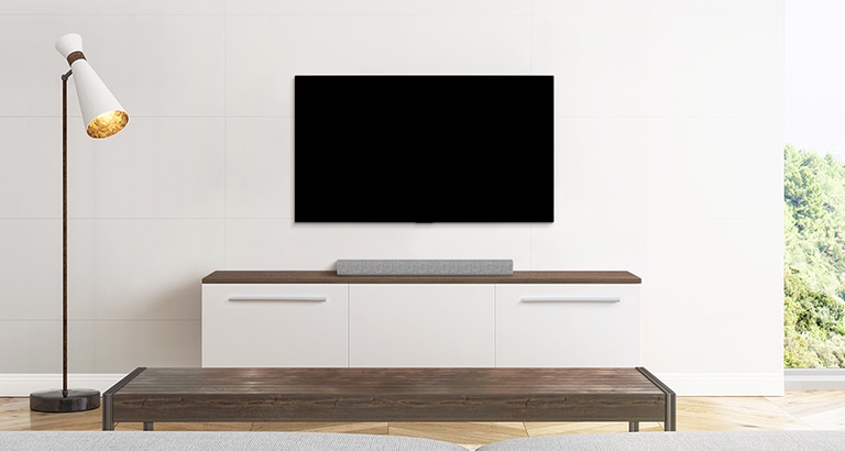 Ein Fernseher und eine Soundbar in einem schlicht eingerichteten Wohnzimmer.