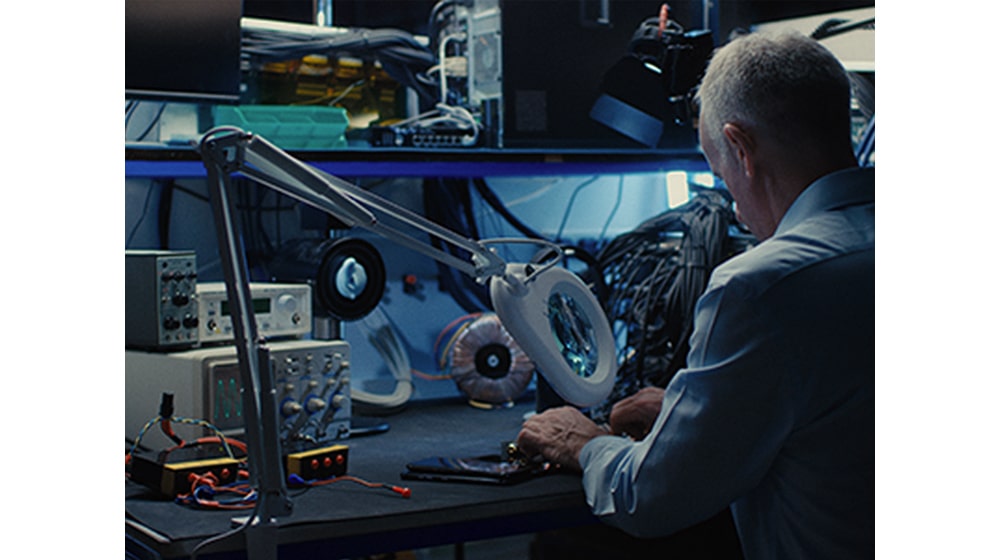 Ein Mann arbeitet an professionellen Maschinen an seinem Schreibtisch.