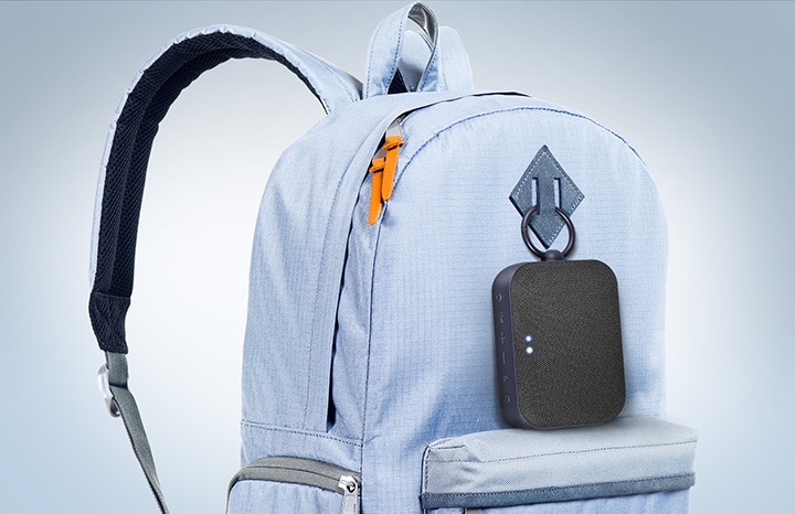 Der LG XBOOM Go DXG1, per Clip an einem himmelblauen Rucksack befestigt.