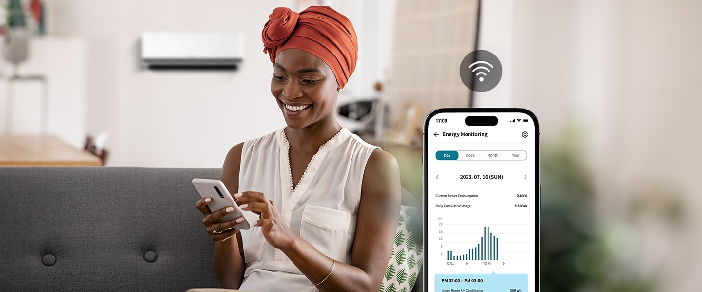 Eine Frau genießt den kühlen Luftstrom der Klimaanlage und überprüft deren Energieverbrauch über den Bildschirm der ThinQ™-App.