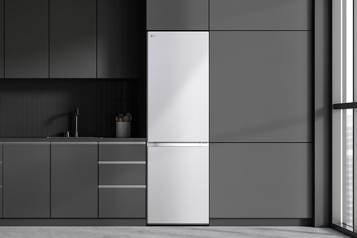 Moderne Küche mit einem Kühlschrank, der sich nahtlos in die umgebenden Schränke einfügt und einem Einbaumodell ähnelt.	