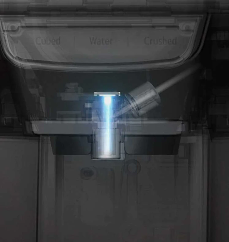La telecamera ingrandisce e il distributore d'acqua nella porta diventa visibile attraverso l'esterno del frigorifero. Immediatamente prima che l'acqua fuoriesca, una luce UV illumina il distributore.