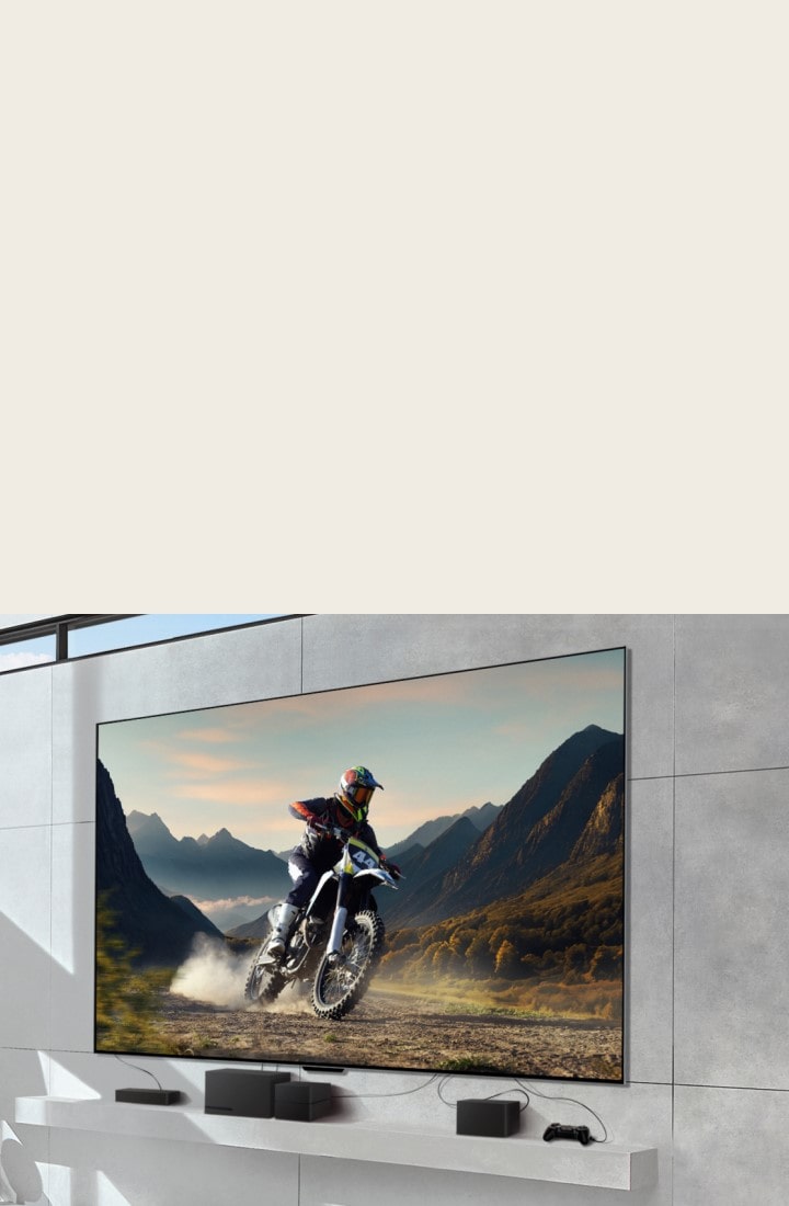LG SIGNATURE OLED M4 mounted on a wall showing a man riding a motorbike on a dirt track, and devices connected to the TV by messy wires underneath. The devices fade and the shot zooms out to reveal a bright, modern living room and a Zero Connect Box on a table with devices neatly organised underneath. The image darkens briefly and highlights the Zero Connect Box and devices. A red Wi-Fi signal appears and a red beam emits towards the TV and red circles eminate.