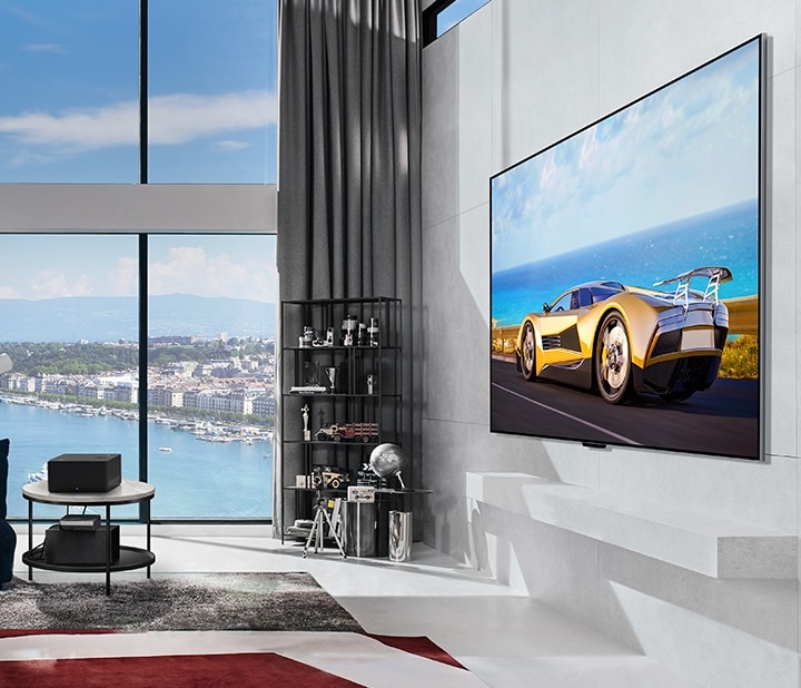 LG SIGNATURE OLED M4 on a stand in front of floor-to-ceiling windows in a sunny, modern apartment.