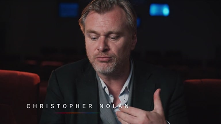 Christopher Nolan gibt ein Interview in einem Kinosaal.