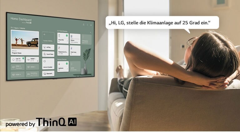 Eine Frau liegt auf einem Sofa und fordert den Fernseher per Sprachbefehl dazu auf, die Temperatur der Klimaanlage zu senken. Auf dem TV-Bildschirm ist das Home Dashboard zu sehen.
