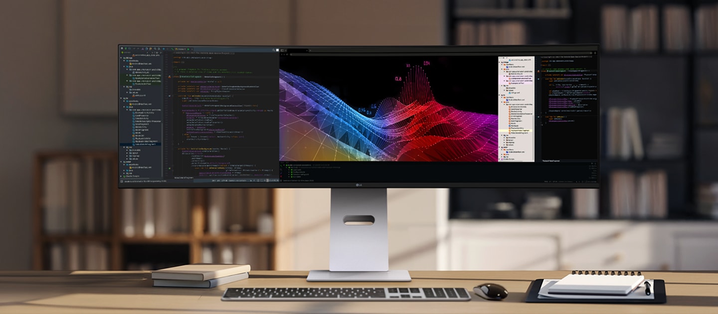 Ein LG UltraWide Monitor, der auf einem Schreibtisch in einem modernen Studienraum platziert ist und neben einem Codierungsprogramm farbenfrohe 3D-Grafiken zeigt.