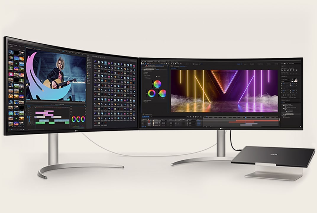 Zwei gebogene Monitore auf einem Schreibtisch, verbunden mit einem Laptop, zeigen Videobearbeitungssoftware und farbenfrohe Visuals für Multitasking.