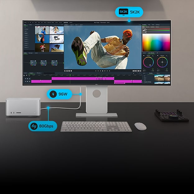 Ein UltraWide-Monitor auf einem Schreibtisch zeigt Videobearbeitungssoftware und ist über ein 5K2K- und SSD/HDD-Setup mit einem Laptop und einem Speichermedium verbunden.