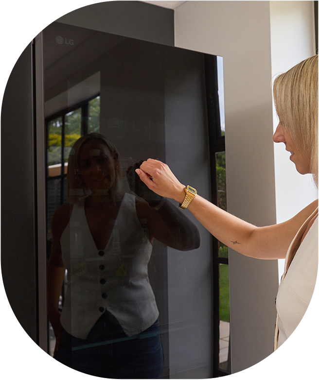 Eine Frau benutzt einen LG InstaView-Kühlschrank und eine Szene, die das Innere des Kühlschranks zeigt.