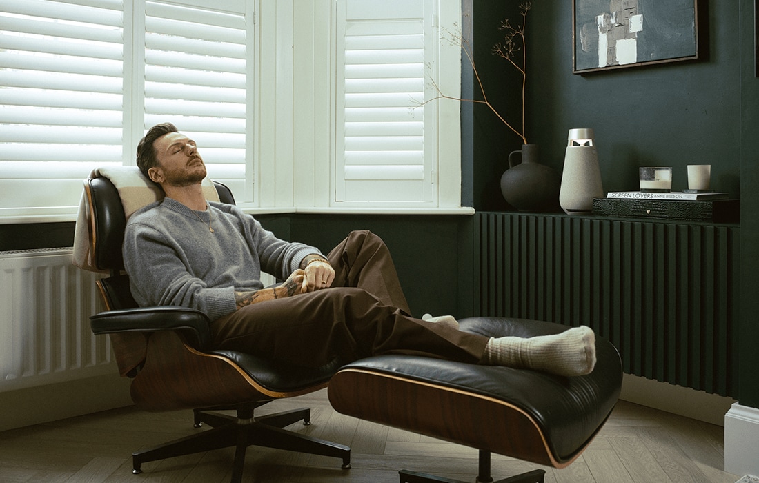 Entspannen auf dem Wohnzimmer-Sessel und Genießen von Musik mit XBoom-Lautsprecher