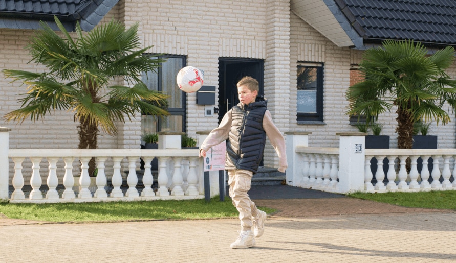 Der Sohn spielt Fußball im Garten
