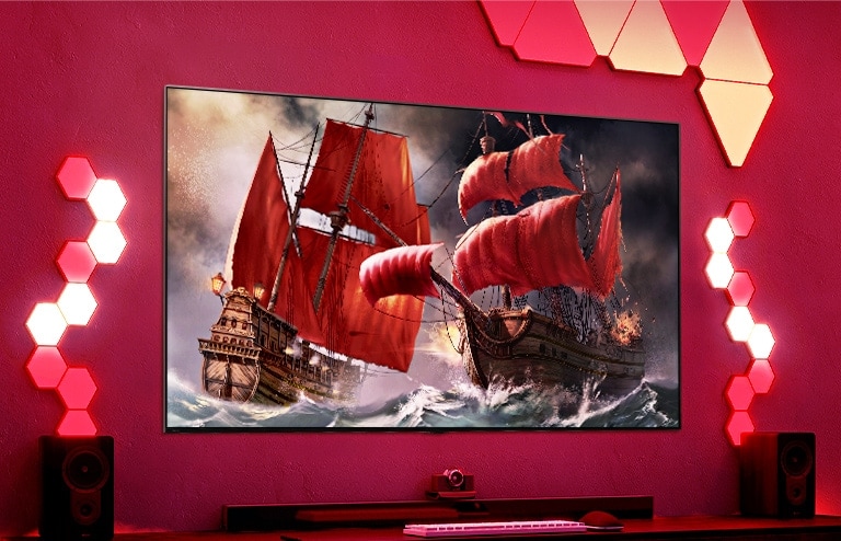 Ein QNED TV hängt an einer roten Wand und auf dem Bildschirm ist ein Piratenschiff zu sehen.