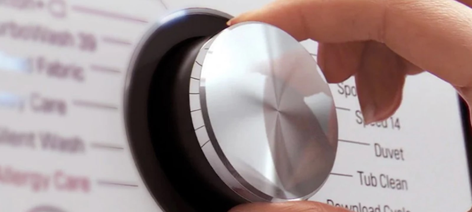 Bild der Hand mit der Steuerung der weißen LG-Waschmaschine.