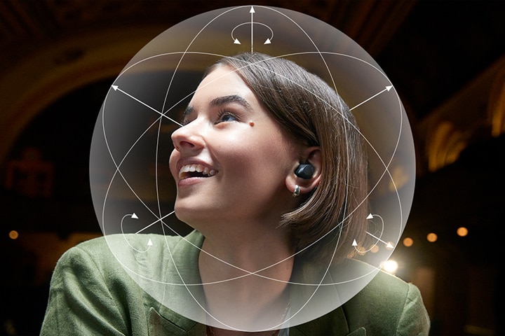 Eine Frau, die die T90S trägt, lächelt. Zur Veranschaulichung der Dolby Head Tracking-Funktion wird eine Kugel um ihren Kopf herum gezeigt.