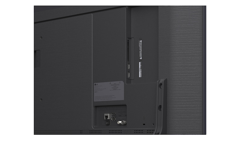 En familie sidder på en sofa og ser på et LG QNED TV, som er monteret på væggen over en LG Soundbar, med en lille pige, som peger på en skærm med to delfiner. Titlen beskriver, hvordan hver handling ser mere fantastisk ud på en ultrastor skærm.