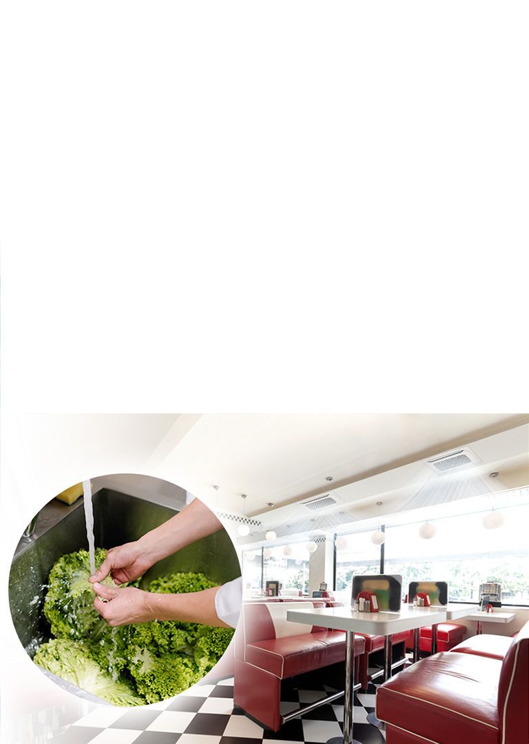 MULTI V S leverer en kølig luftstrøm i et stort cafeteria med rækker af borde og sofaer. Forstørret billede af hænder, der skyller salat med vand i en håndvask.