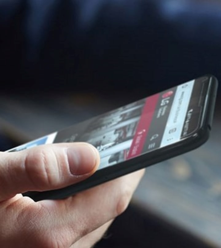 Anmod om at købe. En mand ser på en LG Business-hjemmeside på sin telefon