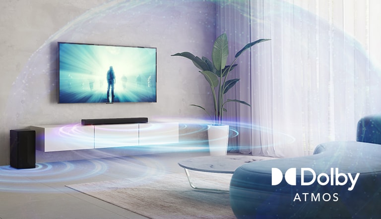 I stuen hænger et LG TV på væggen. En film afspilles på TV-skærmen. LG Soundbar er lige under TV'et på en beige hylde med en baghøjttaler placeret til venstre. Dolby Atmos Virtual-logoet er vist nederst til højre på billedet.