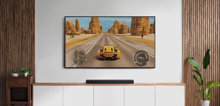 Der er et tv og en soundbar i en stue. Et racerspil vises på en tv-skærm. (afspil videoen)