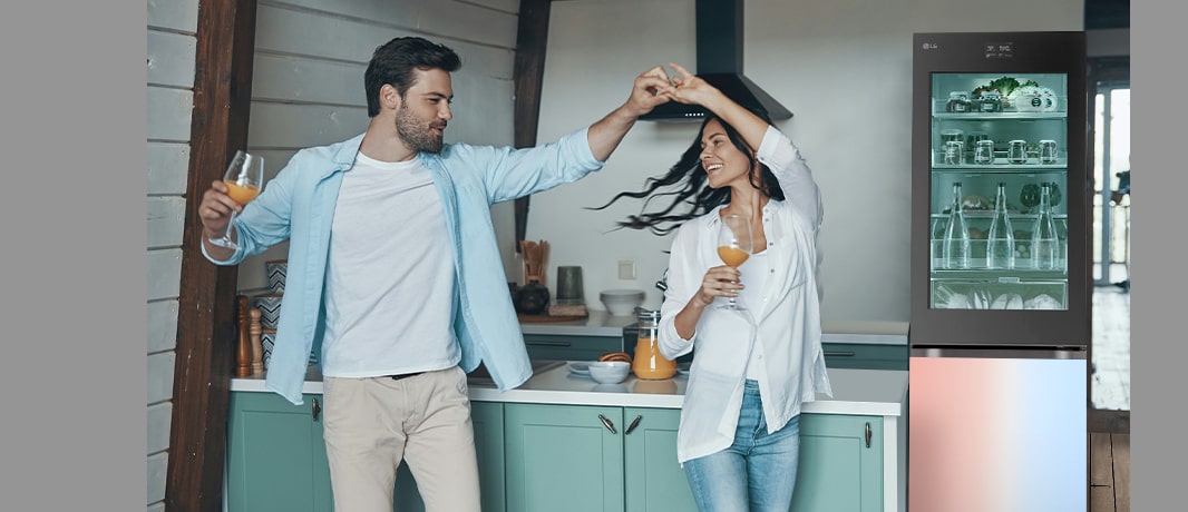 Billede af et par, som danser foran et køleskab med glødende farver.