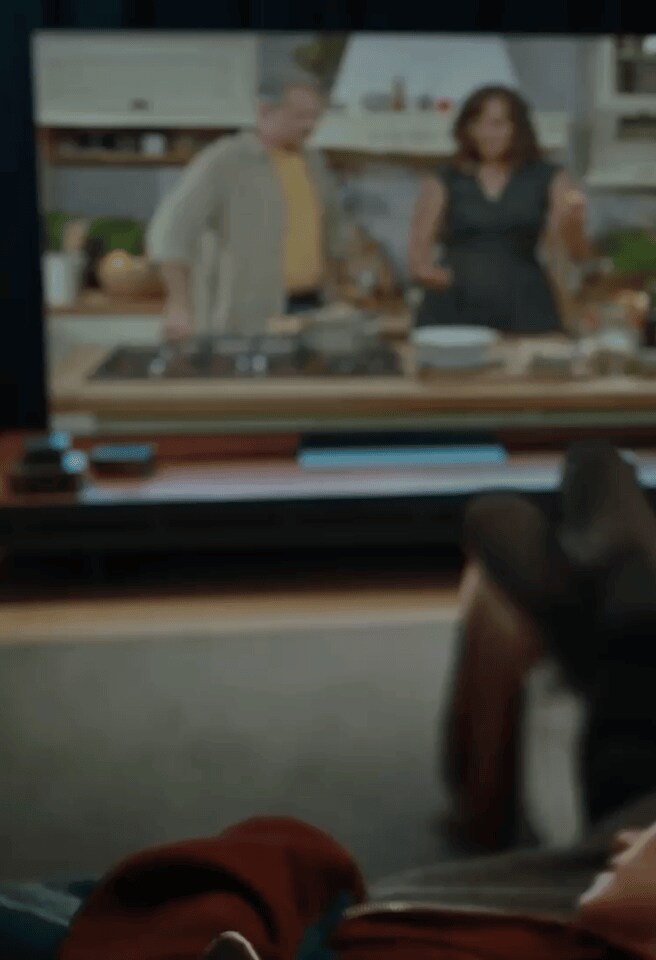 En mand og en kvinde sidder på sofaen og ser en fodboldudsendelse på et LG-tv i stuen. Scenen skifter, og manden og kvinden omfavner hinanden. Kameraet fokuserer på LG XBOOM ved siden af dem.