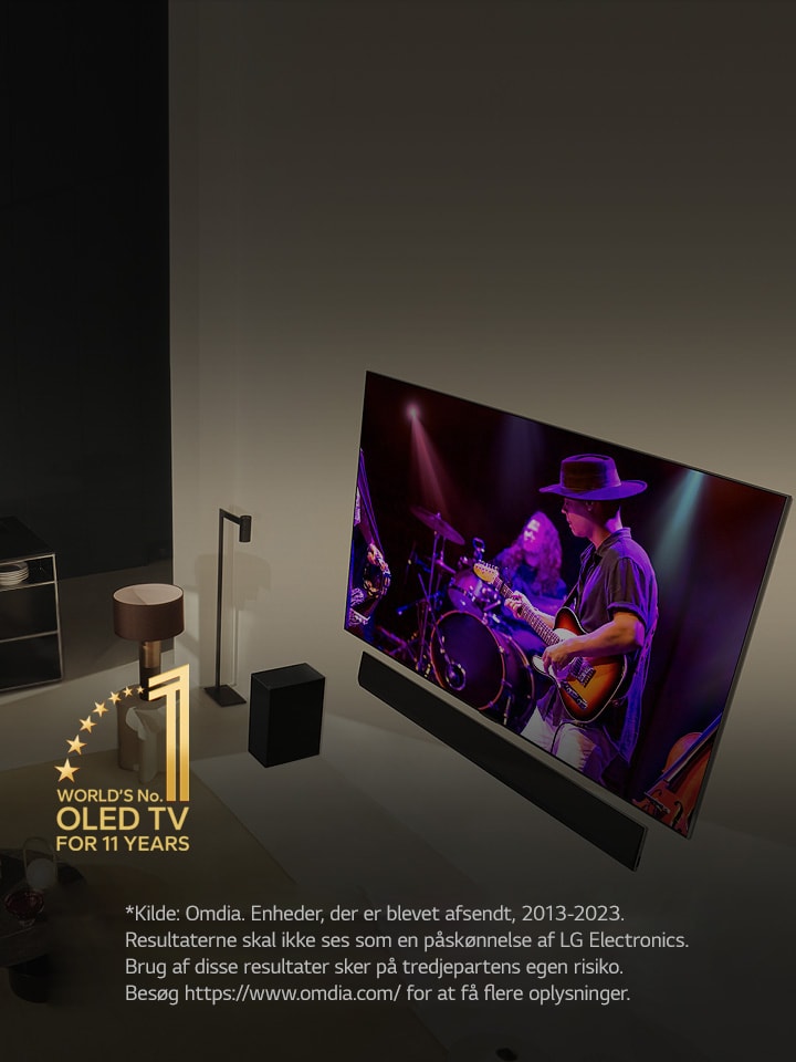 Visning oppefra af en mand og en kvinde, der ser en koncert på et stort OLED TV i en moderne lejlighed. Emblemet “Verdens førende OLED TV i 11 år” ses på billedet. En ansvarsfraskrivelse fremsætter: “Kilde: Omdia. Enheder, der er blevet afsendt, 2013-2023. Resultaterne skal ikke ses som en påskønnelse af LG Electronics. Brug af disse resultater sker på tredjepartens egen risiko. Besøg https://www.omdia.com/ for at få flere oplysninger.”	