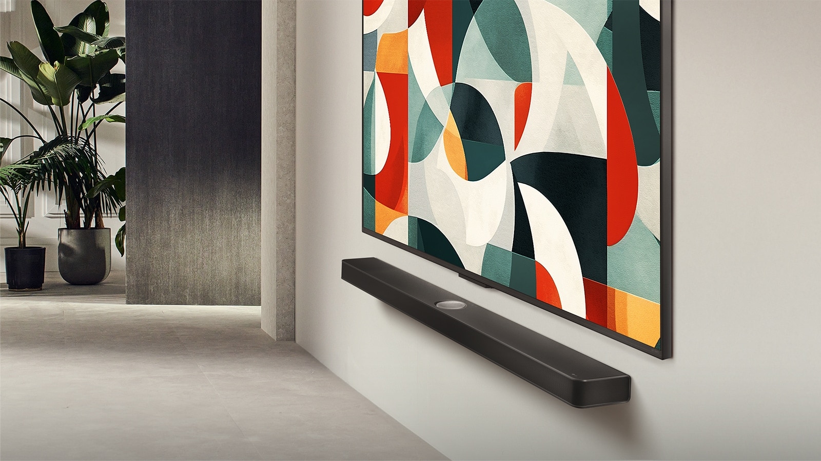 صورة بزاوية بسيطة لتلفزيون LG QNED TV مثبت على جدار فوق مكبر صوت LG Soundbar في غرفة معيشة عصرية. يعرض تلفزيون LG QNED TV خلفية تجريدية بالألوان الأخضر والأبيض والأحمر والبرتقالي.